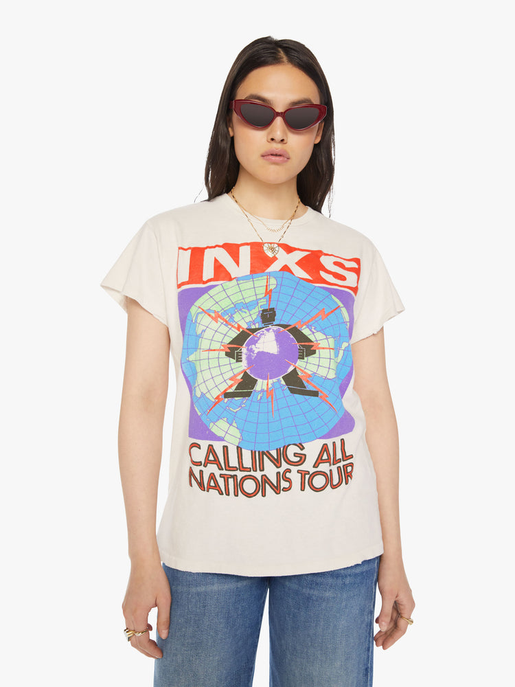 Front view of a woman distressed crewneck tee in white, the tee pays homage to INXS' Calling All Nations tour with bold graphics on the front and back.
