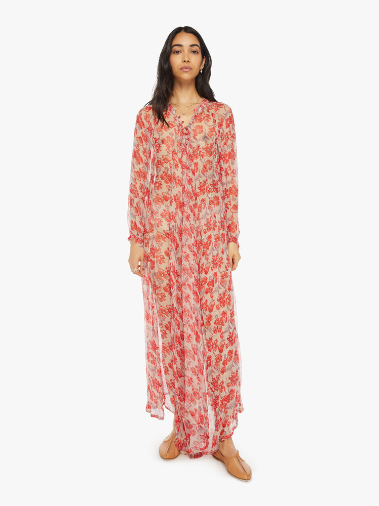 Front view of a woman sheer nude and red watercolor floral print maxi dress with designed with voluminous sleeves and has an A-line cut.
