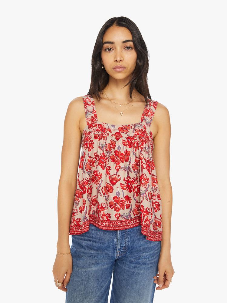 Front view of a woman top in nude with a red watercolor floral print, and features detailed straps and buttons in the back.