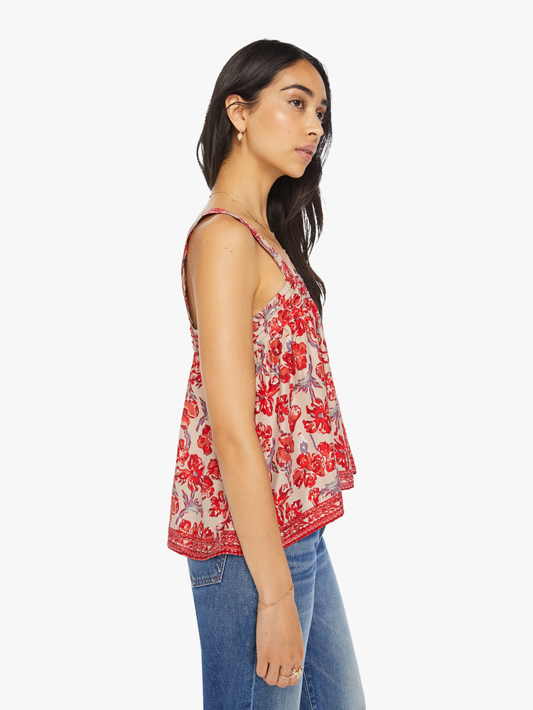 Side view of a woman top in nude with a red watercolor floral print, and features detailed straps and buttons in the back.