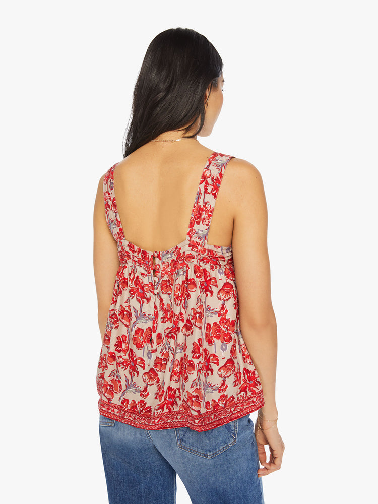 Back view of a woman top in nude with a red watercolor floral print, and features detailed straps and buttons in the back.
