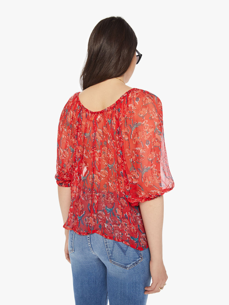 Back view of a woman colorful floral print with a boat neck,3/4-length balloon sleeves and a flowy fit.