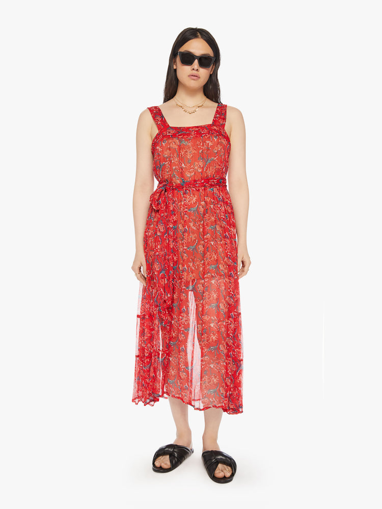 Front view of a woman red maxi dress with colorful print with a square neck, detailed straps, optional waist sash and an ankle-grazing hem.