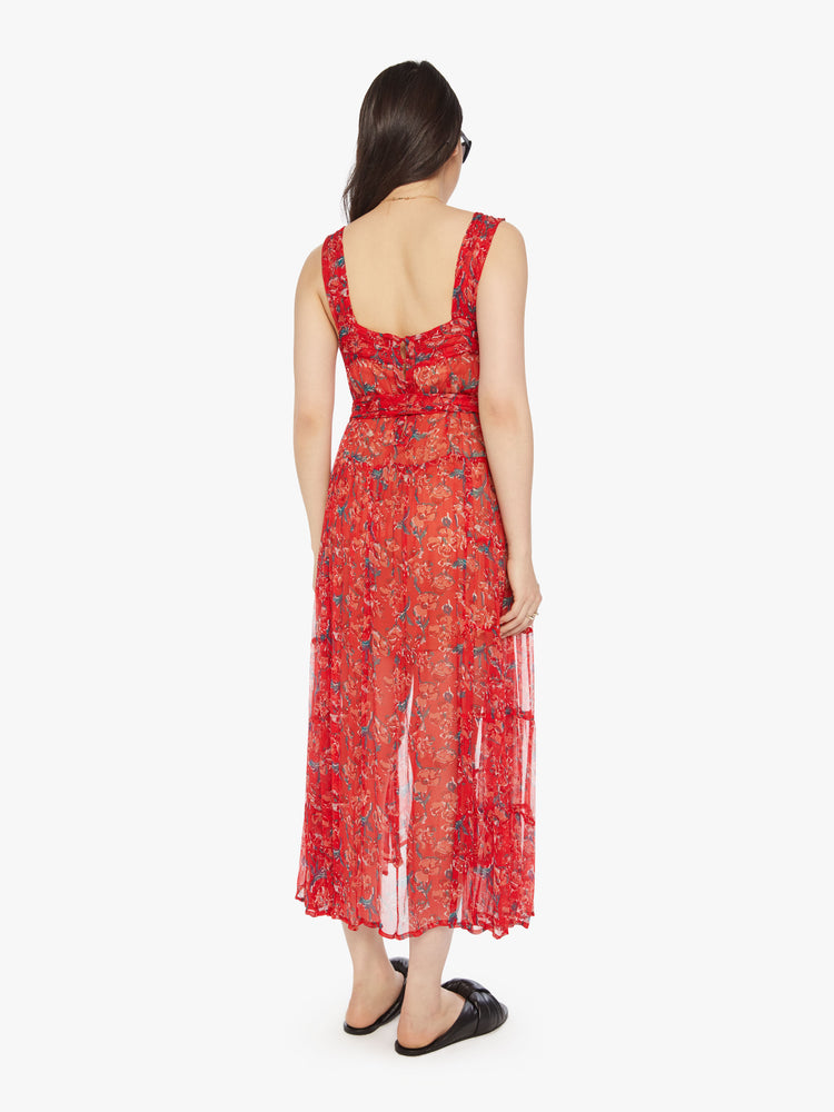 Back view of a woman red maxi dress with colorful print with a square neck, detailed straps, optional waist sash and an ankle-grazing hem.
