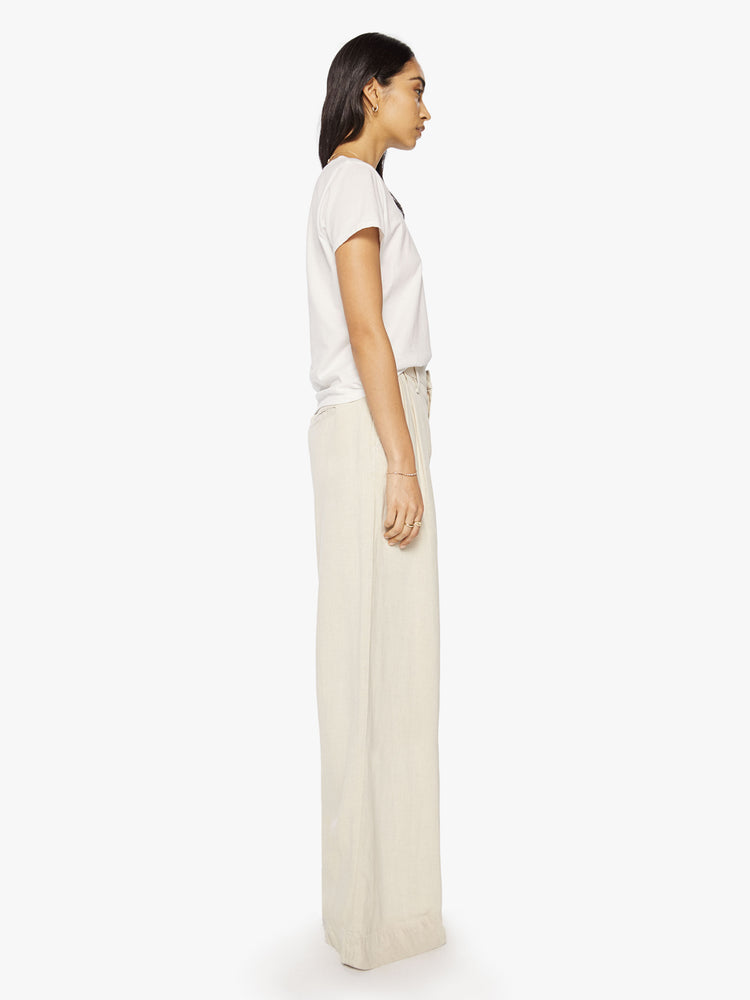 Side view of a woman Super high-waisted wide-leg pants with a long 34-inch inseam that puddles at the hem in a creamy hue.