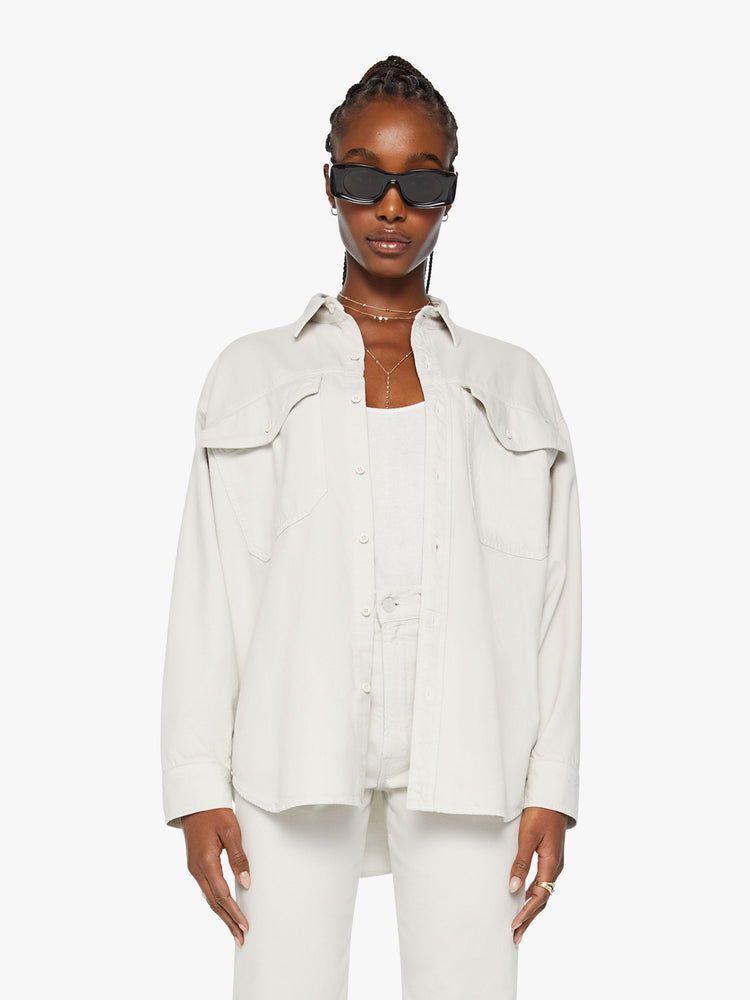 Front view of a woman oversized button-up with drop shoulders, patch pockets and a curved hem in an off white hue.