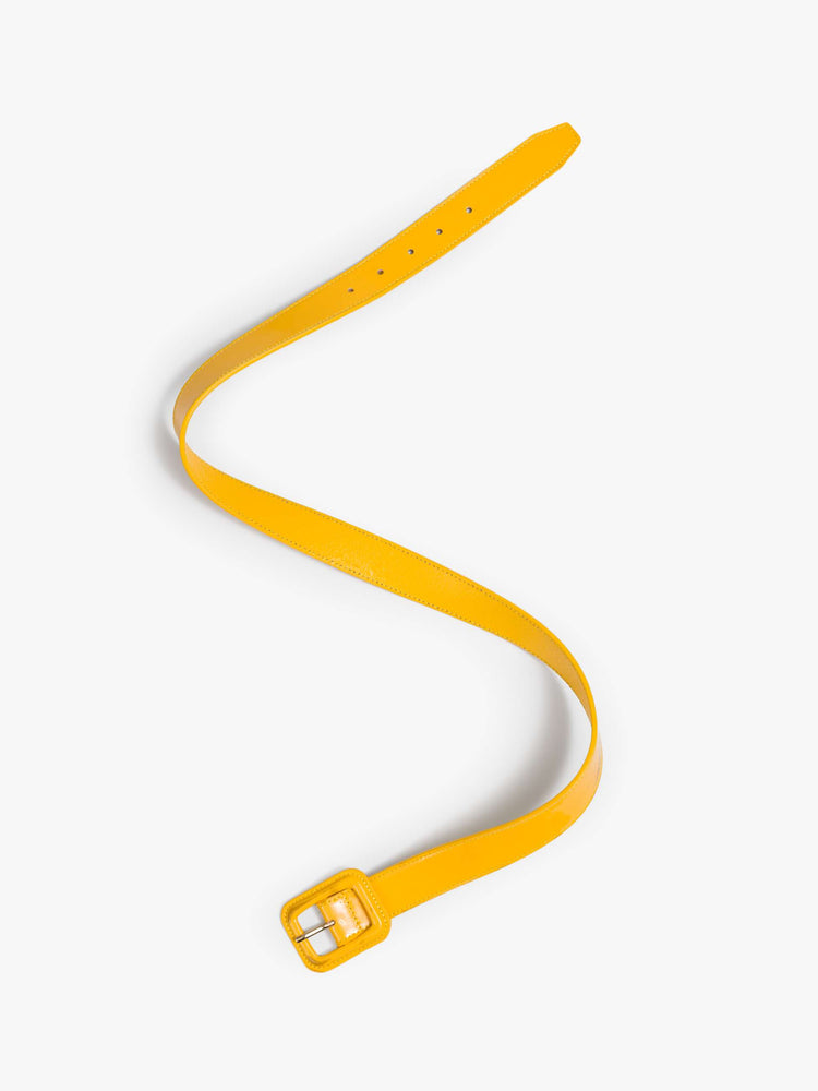 Flat view of a yellow patent leather belt with an oversized square buckle. 