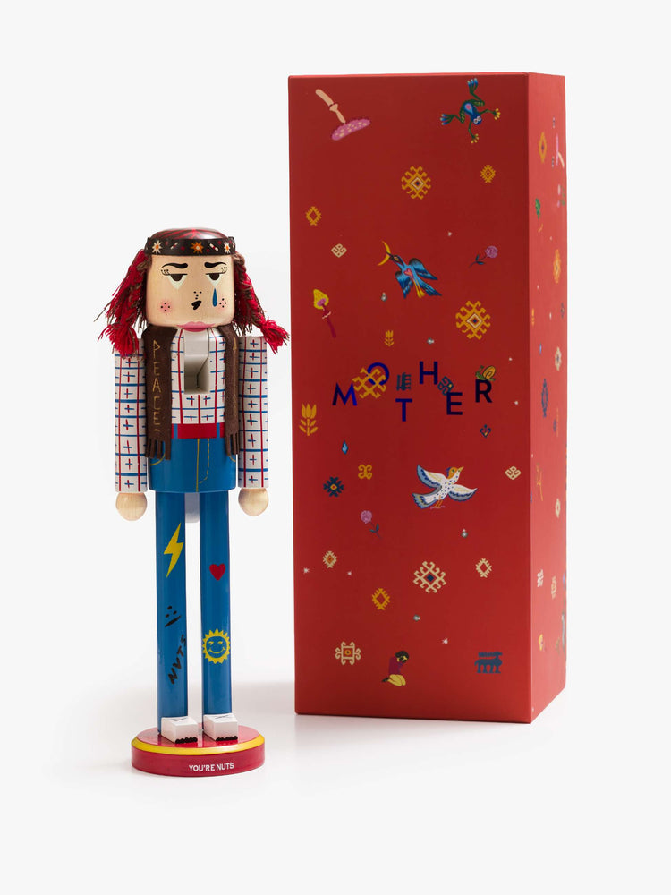 A traditional nutcracker with a headband, embroidered scarf and doodled jeans with packing it comes in.