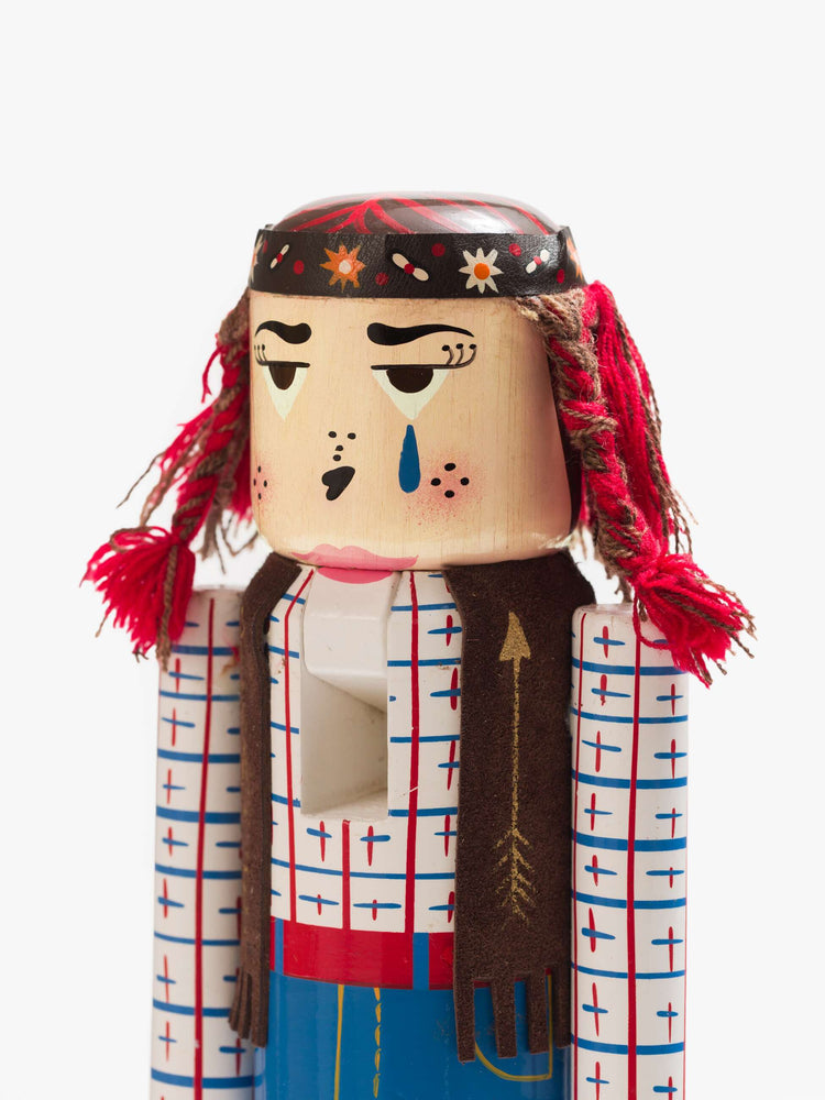 Close up of a traditional nutcracker with a headband, embroidered scarf and doodled jeans.