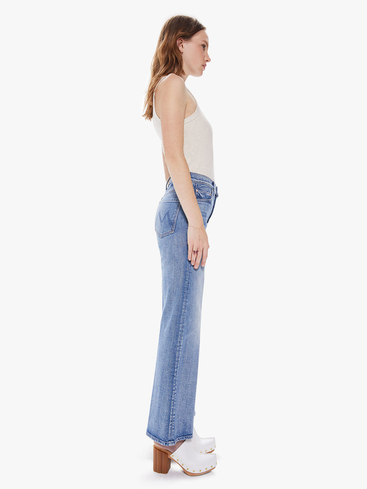 Side view of women's medium blue high waisted wide leg pant with exposed button fly