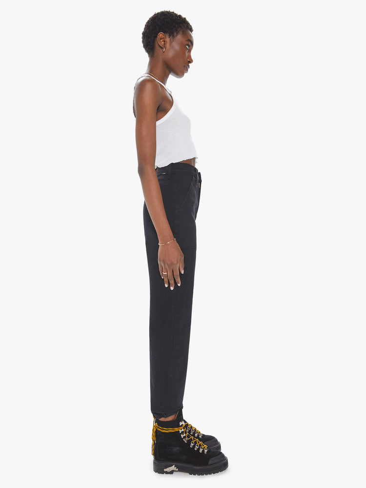 Side view of a womens black wash jean featuring a high waist, front patch pockets, and an elastic cuff hem.