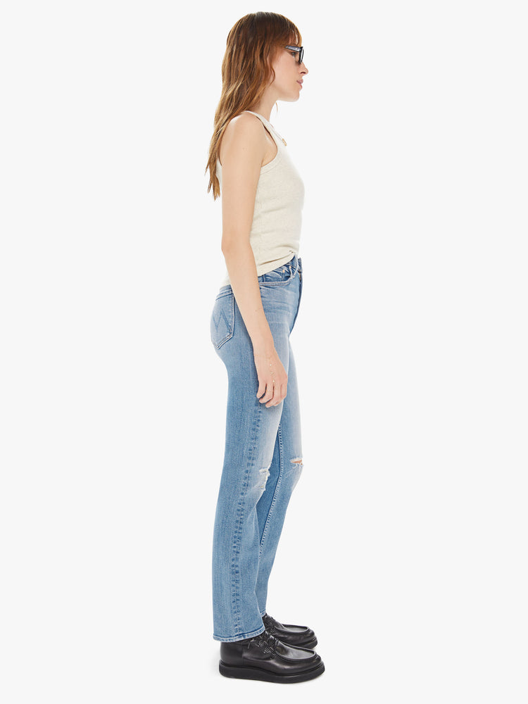 Side view of a women's light blue straight leg jean with a high rise and distressing at the knees