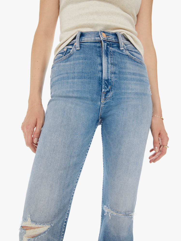 Front detail view of a women's light blue straight leg jean with a high rise and distressing at the knees