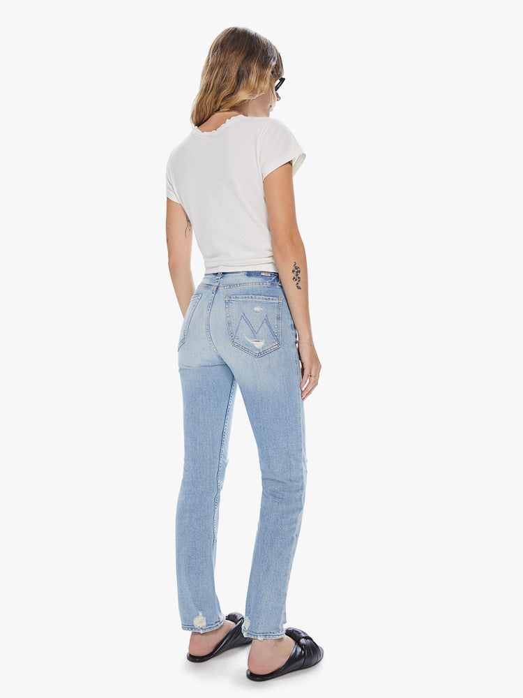 Back view of a womens light blue wash jean featuring a high rise and distressed details throughout.
