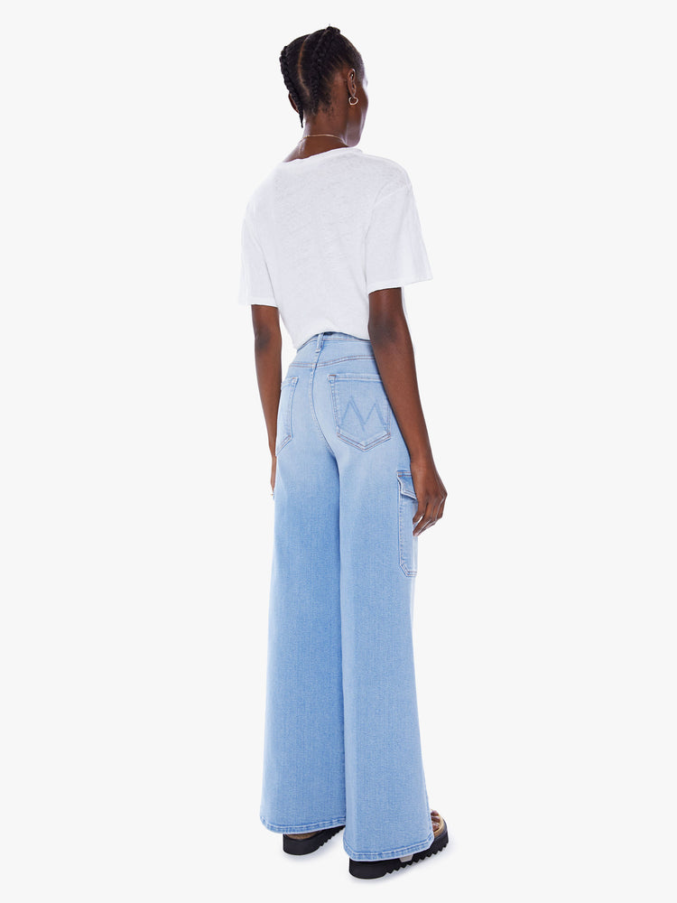 Back view of a woman wide leg cargo pants with a high rise, long 32-inch inseam and patch pockets on the thighs in a light blue wash.