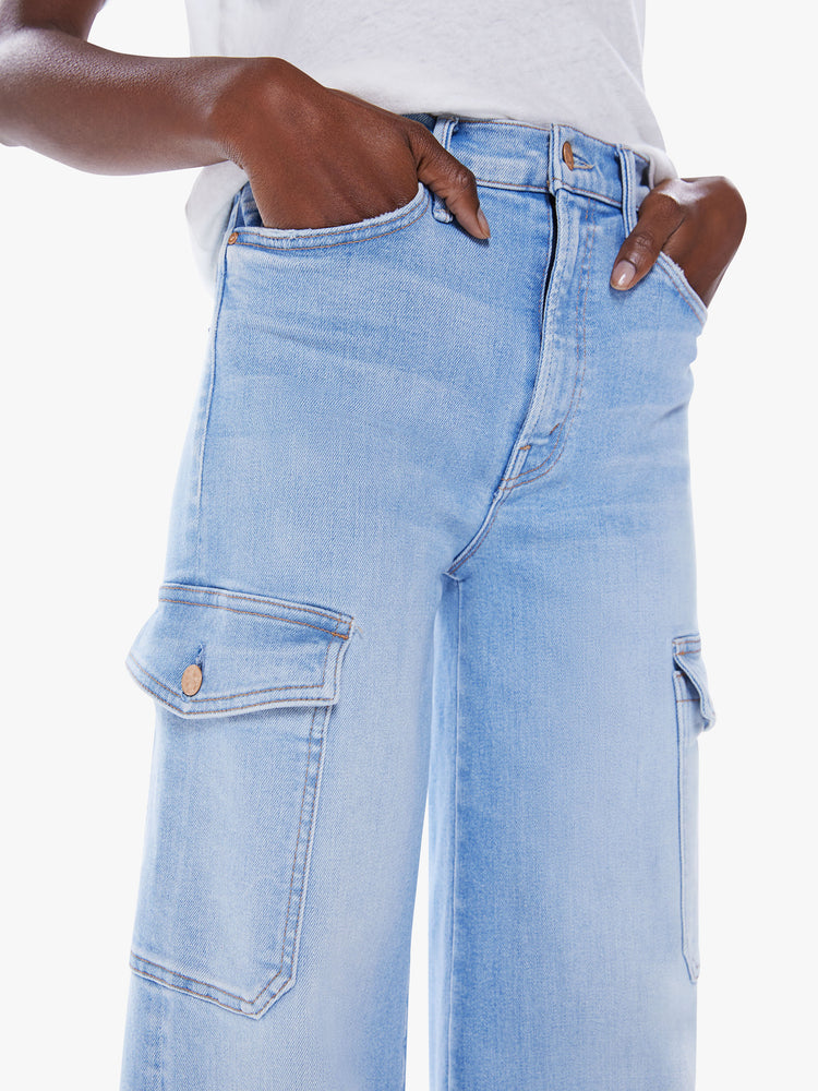 Waist close up view of a woman wide leg cargo pants with a high rise, long 32-inch inseam and patch pockets on the thighs in a light blue wash.