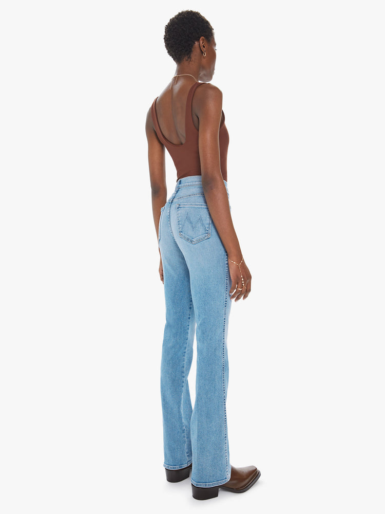 Back view of a womens light blue wash jean featuring a super high rise and a long flare leg.