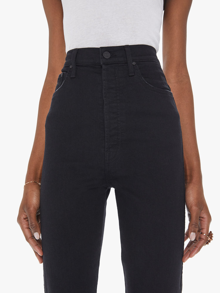 Front close up view of a womens black wash jean featuring a super high rise and a straight leg.