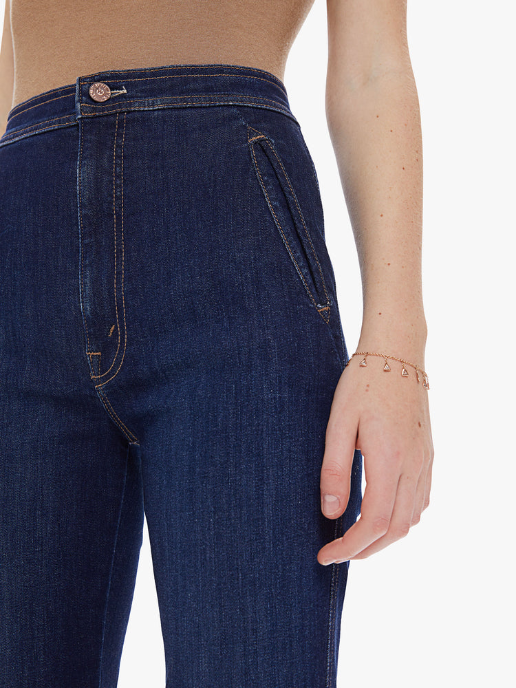 Front detail view of a women's dark blue high rise straight leg jean with welt pockets