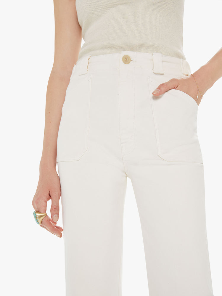 Front close up view of a womens off white pant, featuring a high rise, a wide relaxed leg, and patch pockets.