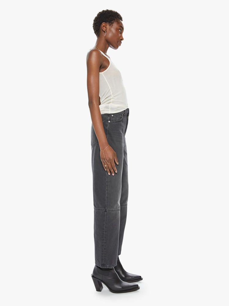 Side view of a women's faded black high rise straight leg jean with a seam detail at the knee. This style is inspired by the fit of 90s jeans.