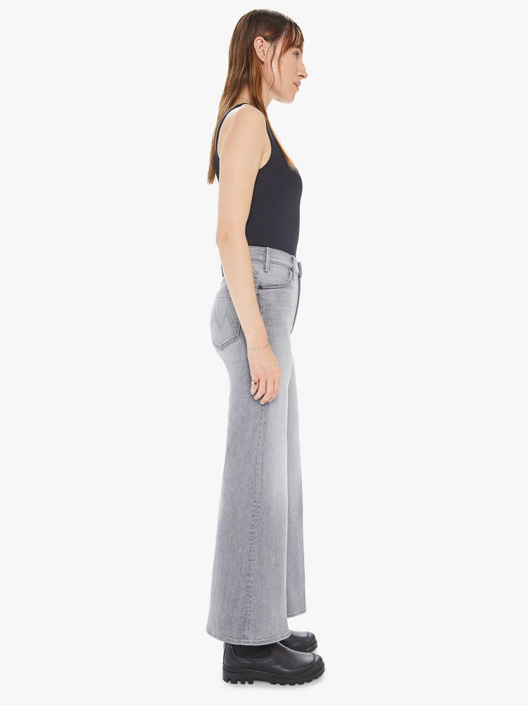 Side view of a womens light grey wash jean featuring a high rise, wide leg, and a clean ankle length hem.