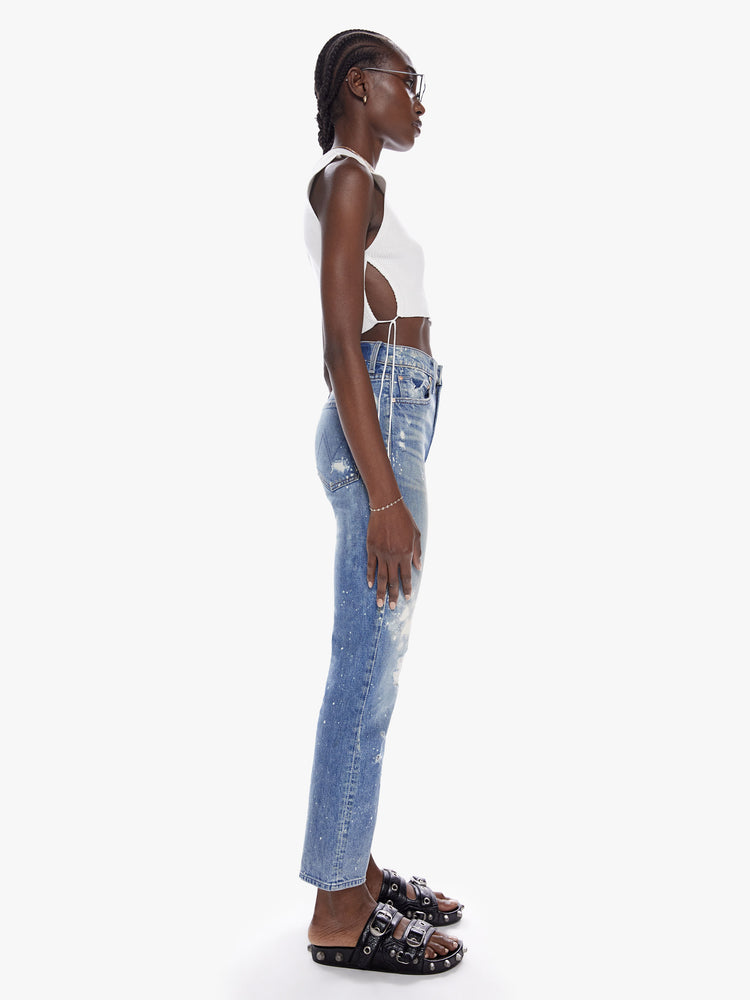Side Full body view of a woman in a perfect high waisted leg jean with ankle length inseam and a clean hem, cut from semi-rigid superior denim in the shade LOL which is a limited edition mid-blue wash with fading,whiskering, paint splatters and bleaching all done by hand