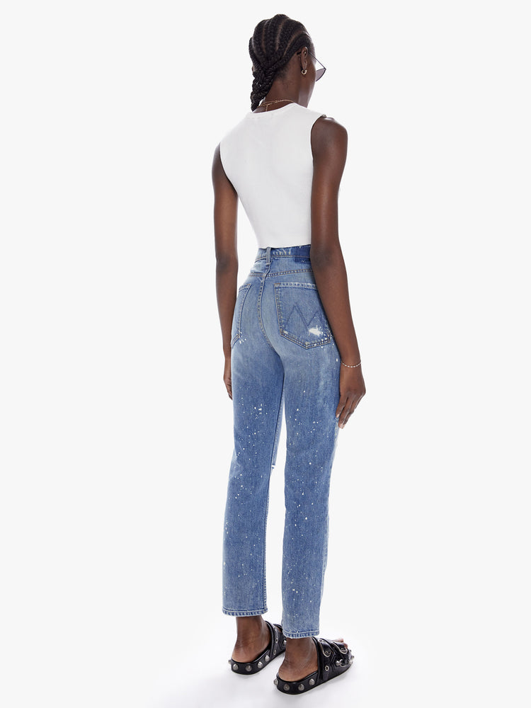 Back Full body view of a woman in a perfect high waisted leg jean with ankle length inseam and a clean hem, cut from semi-rigid superior denim in the shade LOL which is a limited edition mid-blue wash with fading,whiskering, paint splatters and bleaching all done by hand