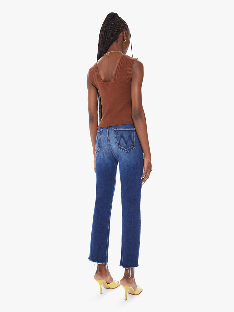 Back view of a women's deep blue straight leg ankle jean with fading