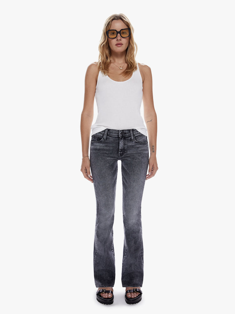 Front view of a woman in a super low rise flare with a long 34 inch inseam and a clean hem cut from soft stretch denim, in a black mineral wash with a high contrast fading throughout