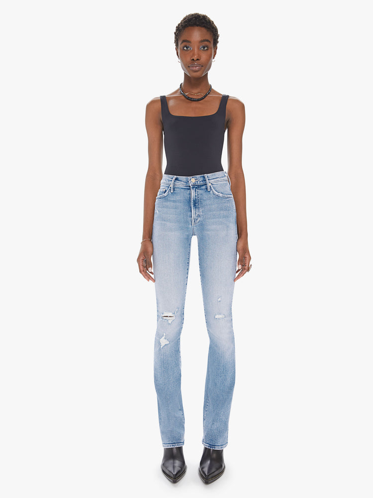 Front view of a womens light blue wash jean featuring a high rise, flare leg, and distressed details at the knees.