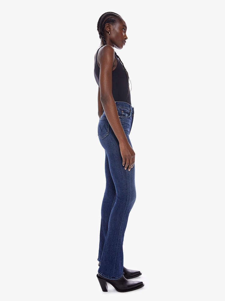 Side view of a dark blue wash denim skinny flare featuring a high rise.