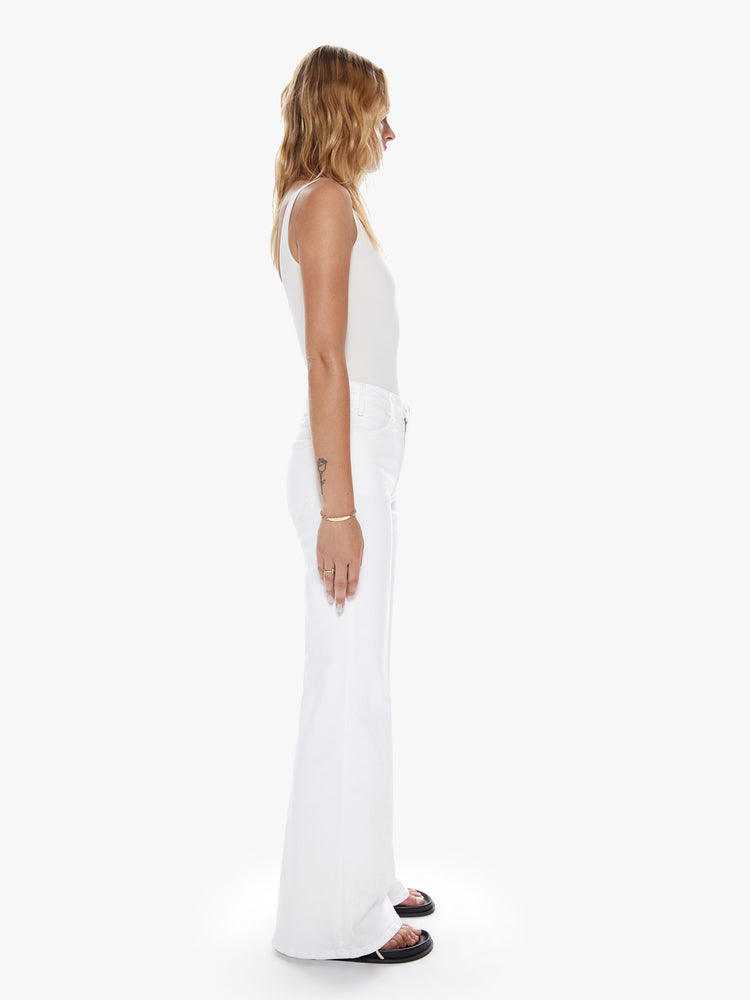 Side Full body view of a woman in a white 70's inspired wide leg with high rise, 31 inch seam and clean hem