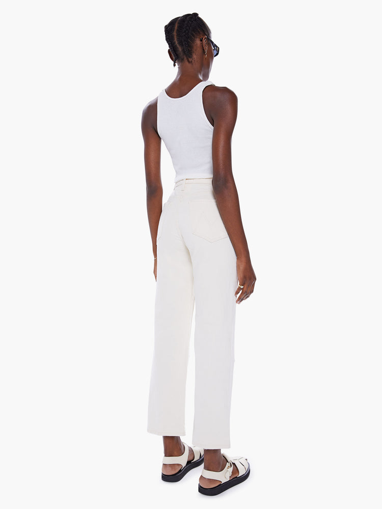 Back view of woman High-waisted pants with a wide straight leg, zip fly, oversized patches at the knees and clean ankle-length inseam in a creamy white hue.
