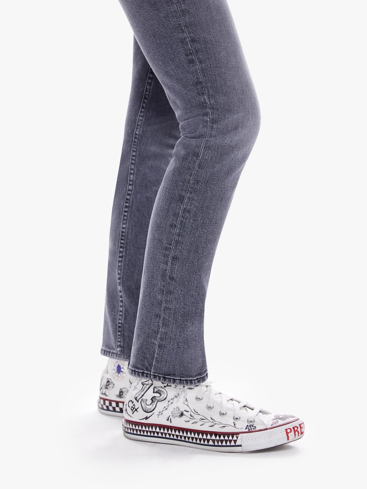 Hem view of a woman in a midrise straight leg jean with an ankle length inseam and a clean hem in a faded black wash with distressing and tears for a worn-in look