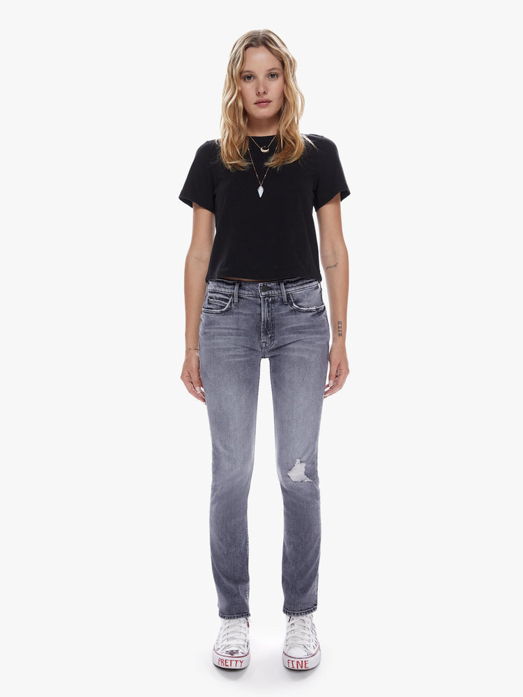 Front full body view of a woman in a midrise straight leg jean with an ankle length inseam and a clean hem in a faded black wash with distressing and tears for a worn-in look