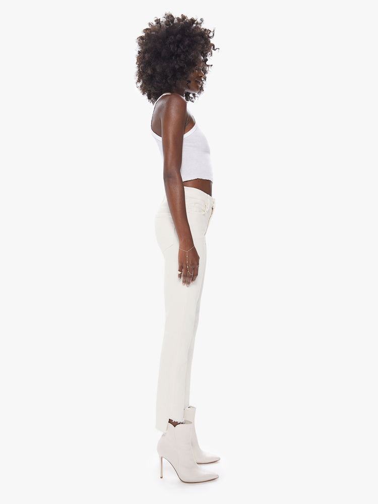 Side view of a women's mid rise straight leg pant with an ankle length step frayed hem