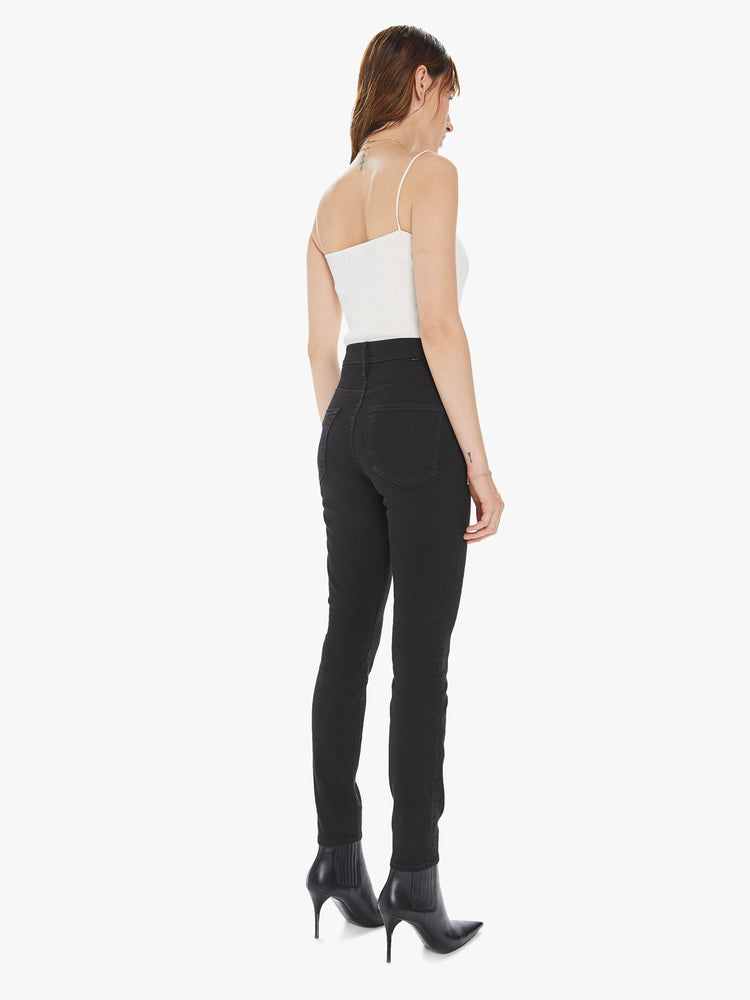 Back view of a women's black high waisted skinny jean with double pocket details