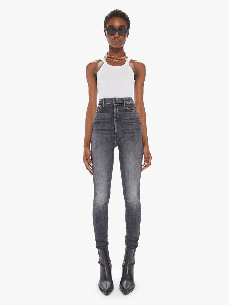 Front view of a womens faded black wash jean, featuring a super high rise and a skinny leg.