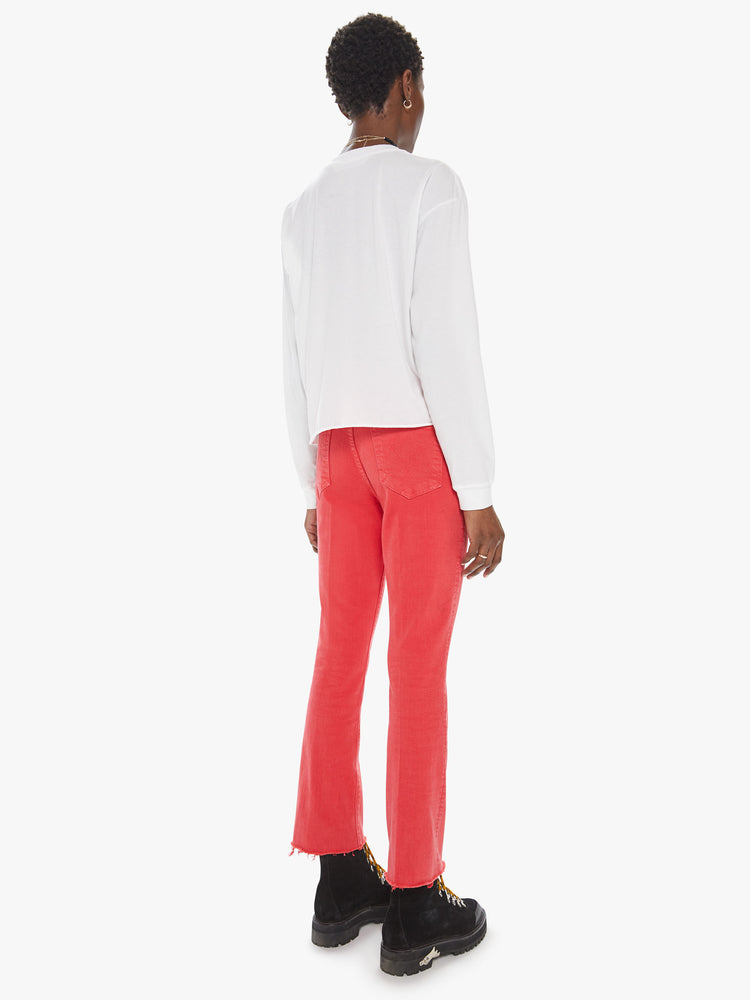 Back view of a womens red flare leg jean featuring a raw cut hem.