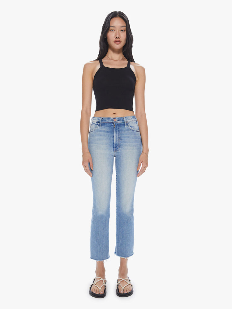 Front view of a womens high rise jean in a light blue wash, featuring a flare leg with a raw hem.