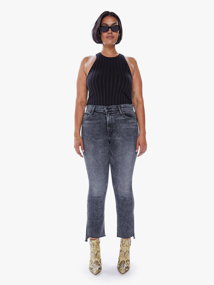 Front view of a womens high rise jean in a mineral washed black denim featuring an ankle length step fray hem.