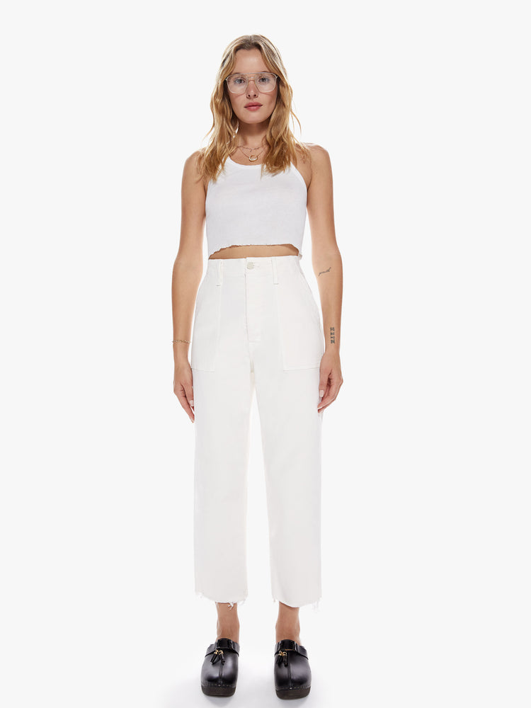 Full body view of a woman in a cargo pant features a high rise, wide leg, button fly, and frayed ankle-length hem in a off-white hue with oversized utilitarian pockets on the front and back