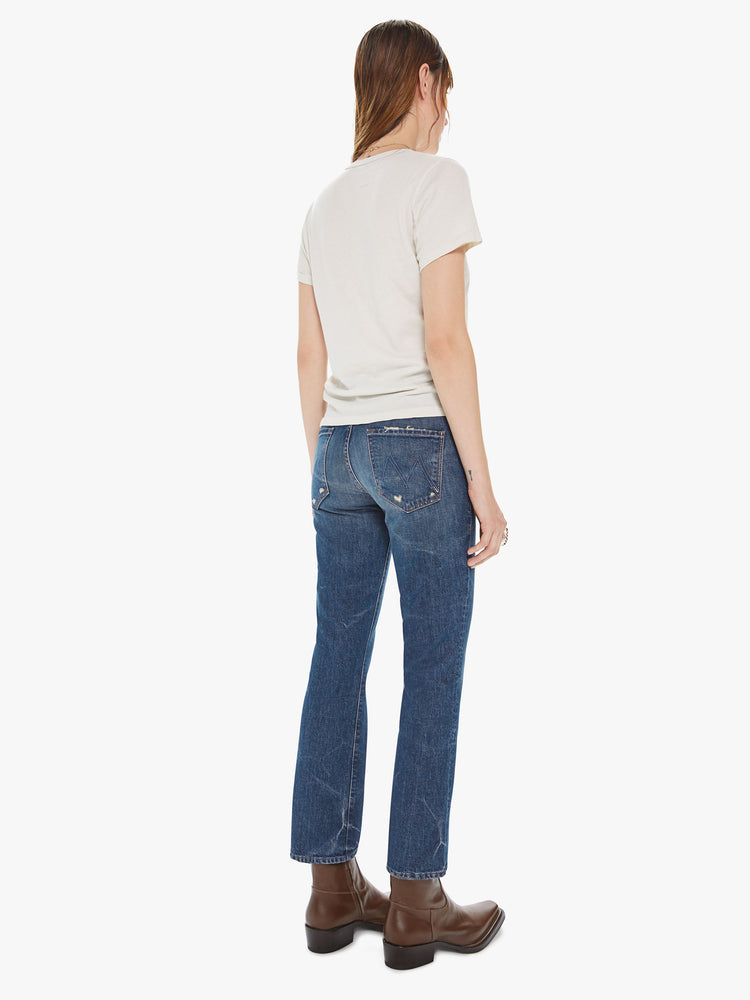 Back view of a womens dark denim wash jean featuring a mid rise and an ankle length bootcut.