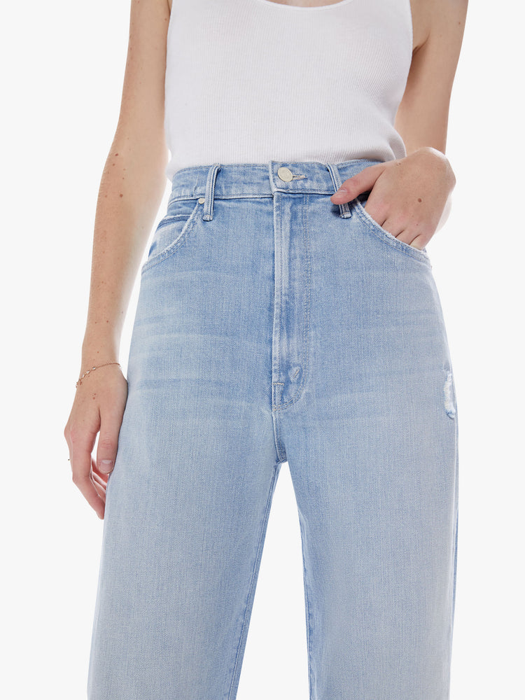 Close up waist view of a womans light blue Super high-waisted jeans with a loose fit, slightly dropped crotch and a wide leg with a 32-inch inseam.
