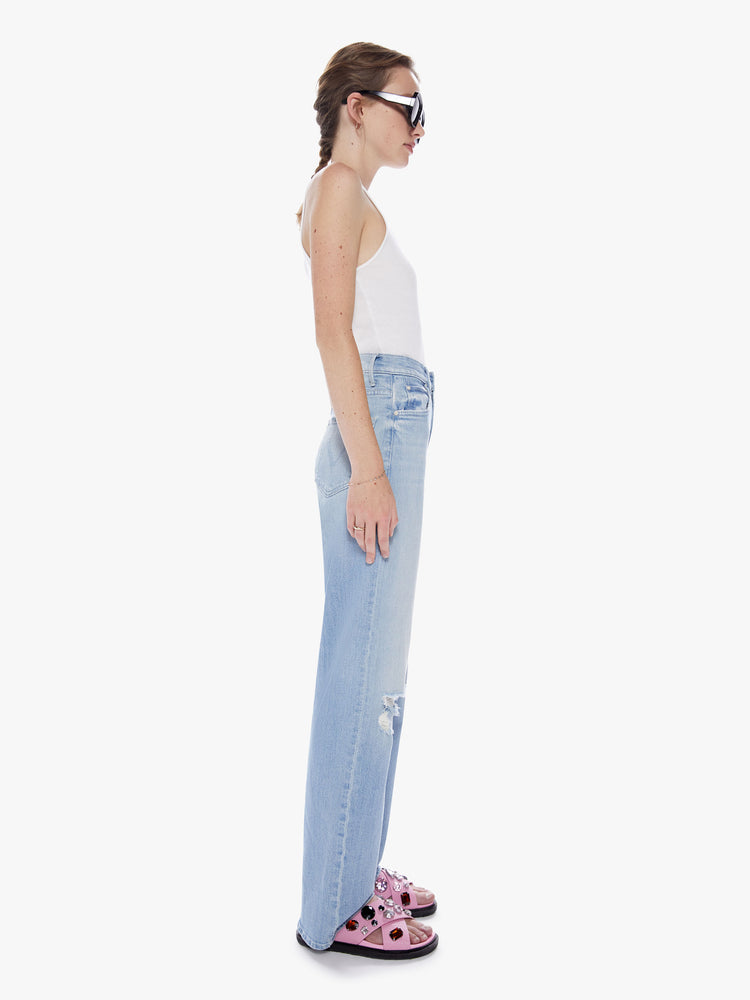 Side view of a womans light blue Super high-waisted jeans with a loose fit, slightly dropped crotch and a wide leg with a 32-inch inseam.