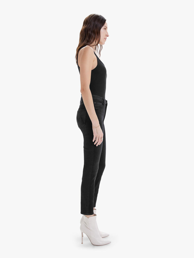 Side view of women's black high rise skinny jean with clean hem