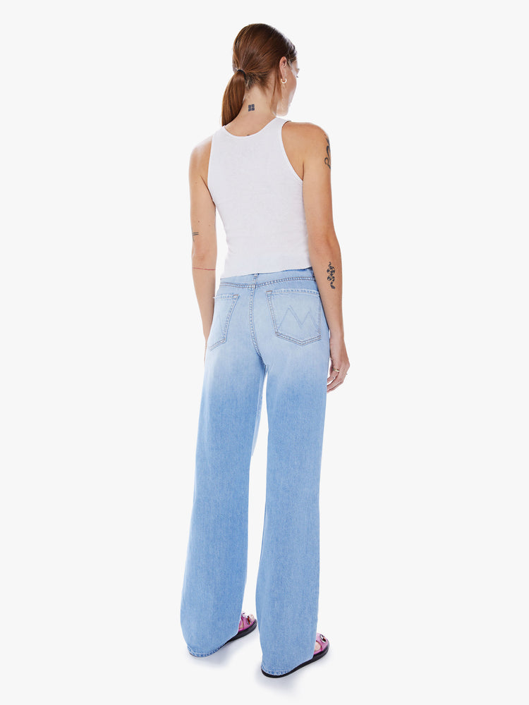 Back view of a woman's High-waisted jeans with a loose fit, wide leg and 34-inch inseam, with a clean hem in a light blue wash.