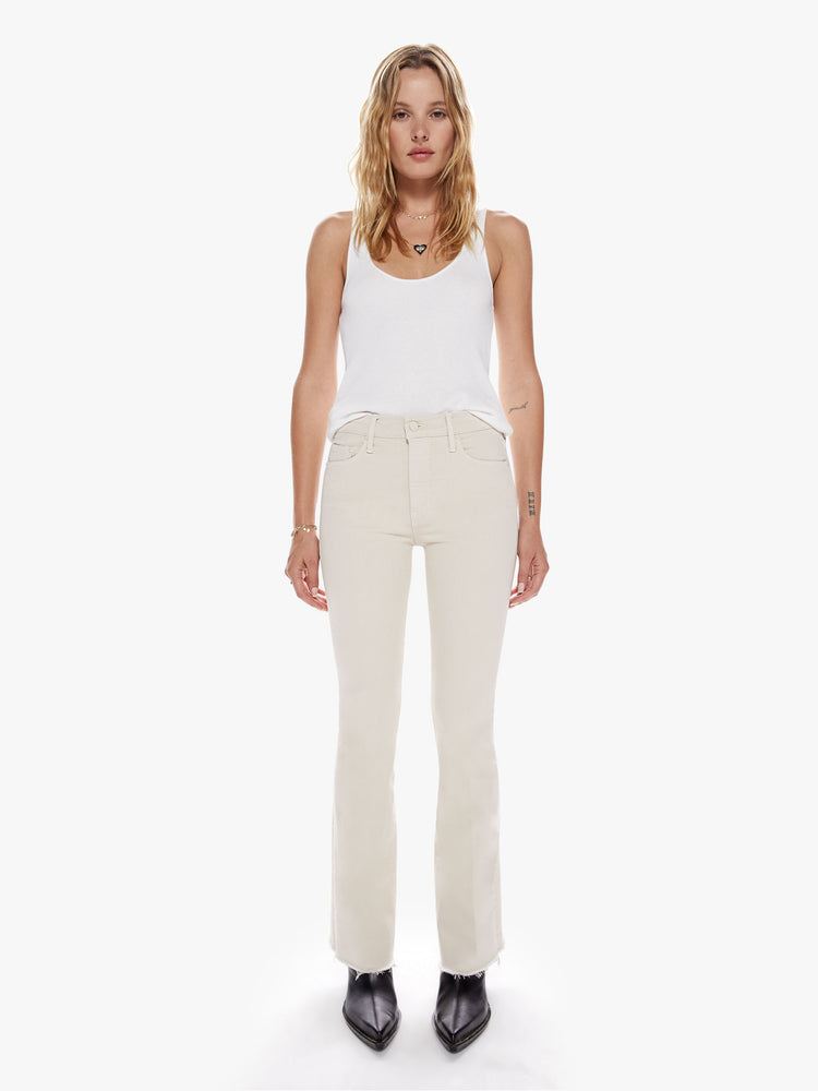 Front view of womens cream-grey mid rise jean with a flare leg and frayed hem