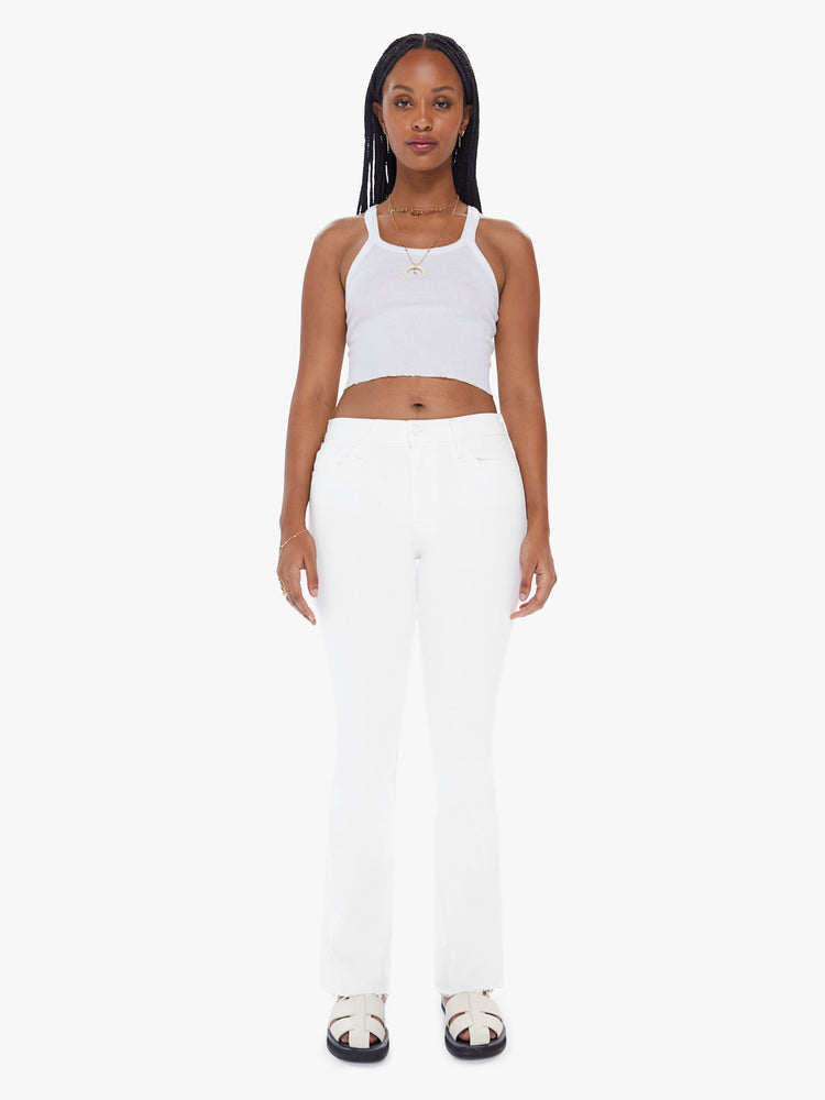 Front view of a womens white wash jean featuring a mid rise, flare leg, and a frayed hem.